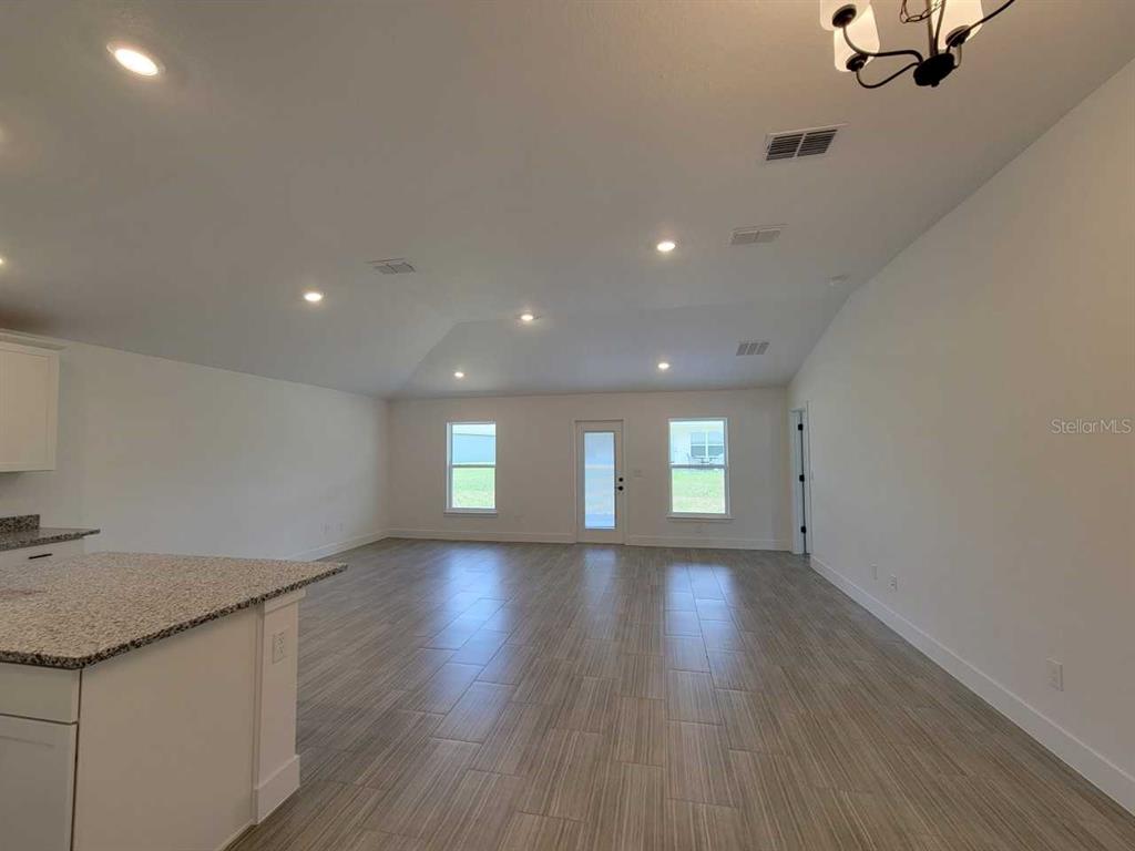 An open-concept living area features light-colored tile floors, a vaulted ceiling, and recessed lighting — 4386 SW 92ND PLACE ROAD, OCALA, FL
