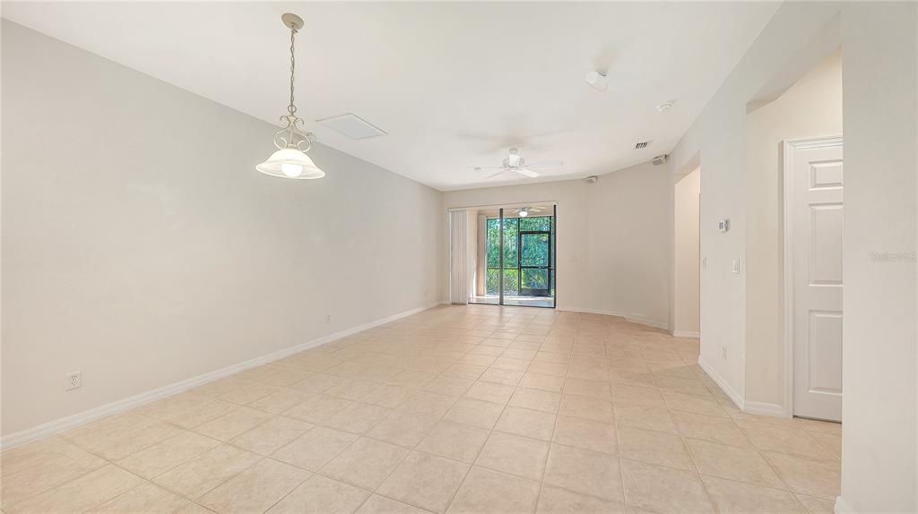 A sunroom with tiled floors, a ceiling fan, and a screened wall overlooking trees — 1821 BATELLO DRIVE, VENICE, FL