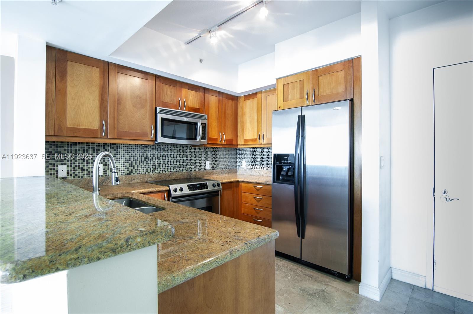 A kitchen features wood cabinets, granite countertops, stainless steel appliances, and a mosaic tile backsplash — 1745 E Hallandale Beach Blvd # 1508W, Hallandale Beach FL 33009, HALLANDALE BEACH, FL