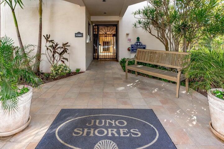 An outdoor entryway features a tiled floor, a wooden bench, and a Juno Shores mat — 420 Celestial Way Way # 206, Juno Beach FL 33408, JUNO BEACH, FL
