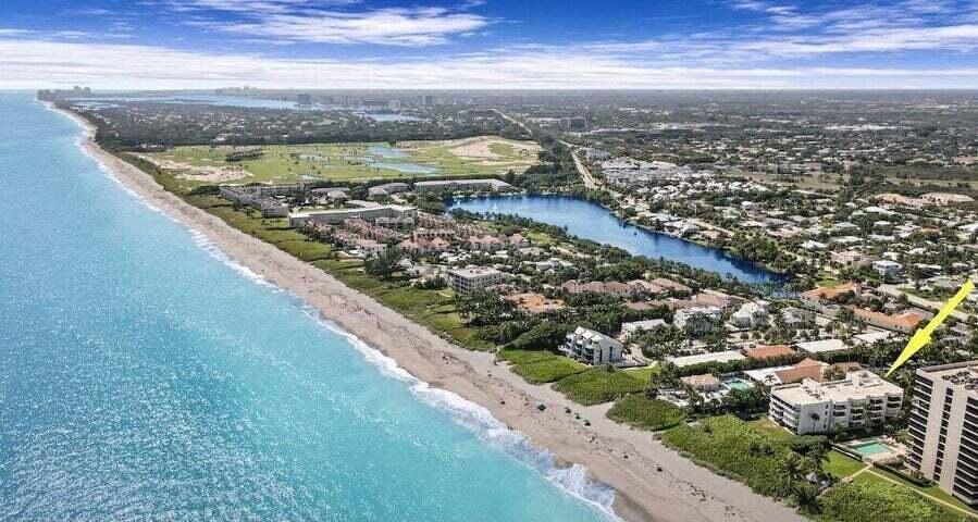 An aerial view shows a beachfront condominium complex with a pool along the coast — 420 Celestial Way Way # 206, Juno Beach FL 33408, JUNO BEACH, FL