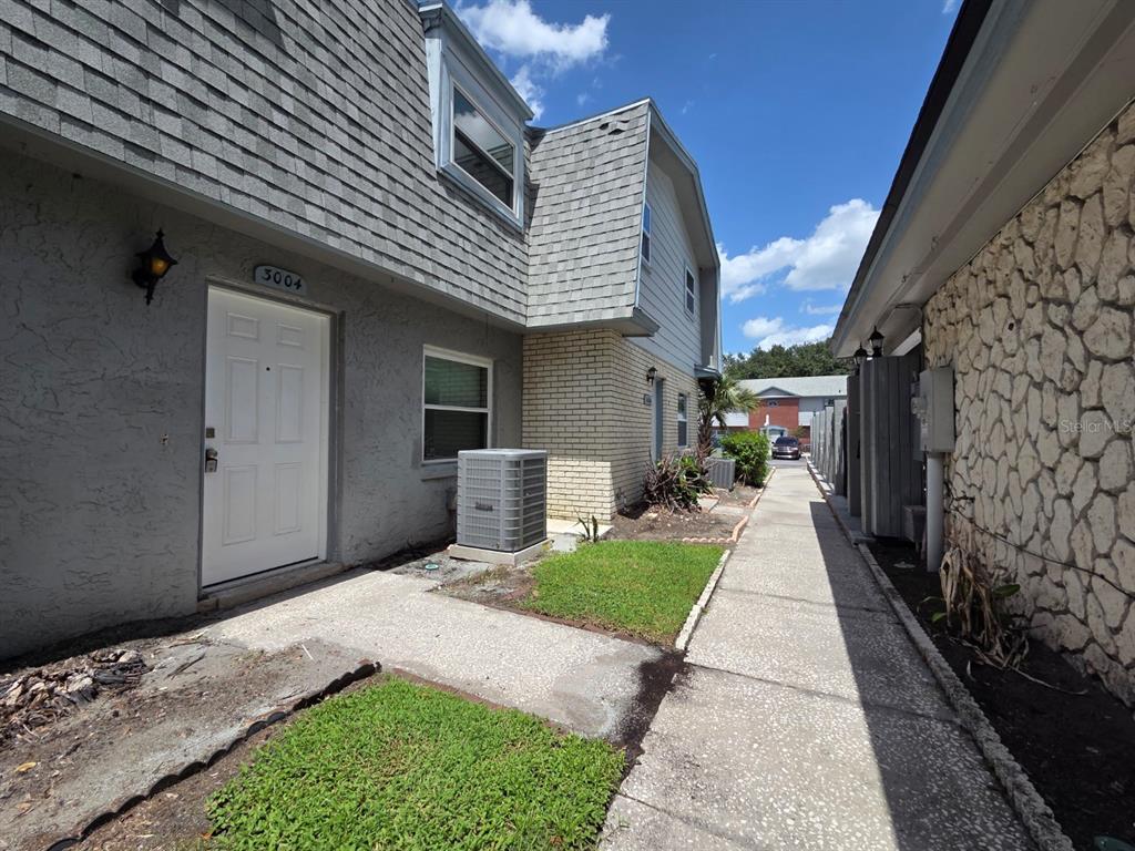 An exterior view of a two-story townhouse with a gray facade and a concrete walkway — 3004 GEORGE MASON AVENUE UNIT K5, WINTER PARK, FL