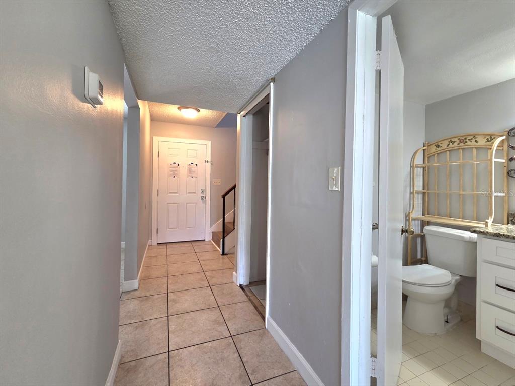 A tiled hallway leads to a front door, with a bathroom visible on the right — 3004 GEORGE MASON AVENUE UNIT K5, WINTER PARK, FL