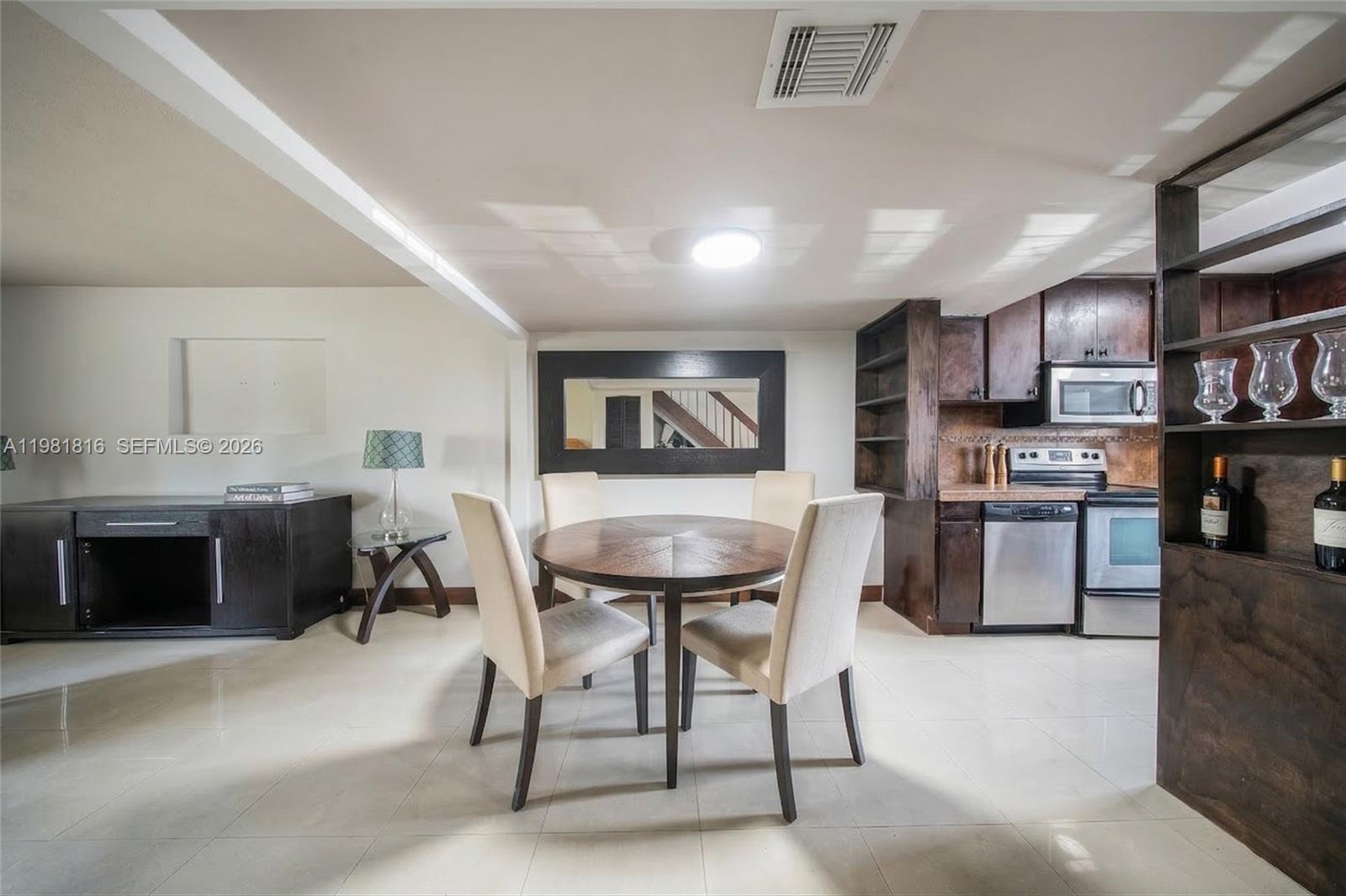 A dining area with a round table and four chairs sits adjacent to a kitchen — 10710 NW 7th St # 11B, Miami FL 33172, MIAMI, FL