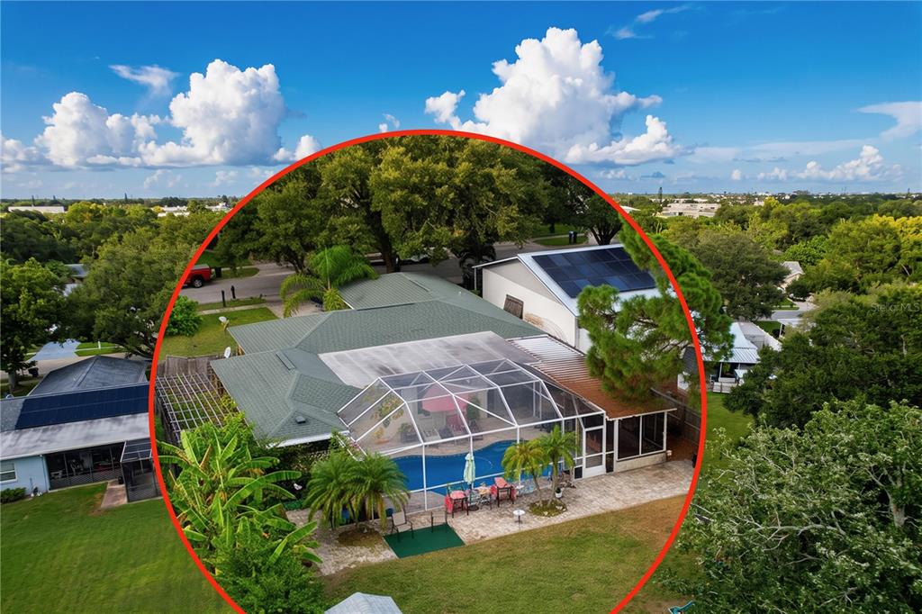 An aerial view shows a house with a screened-in pool, patio, and green shingled roof — 6250 CEDARBROOK DRIVE N, PINELLAS PARK, FL