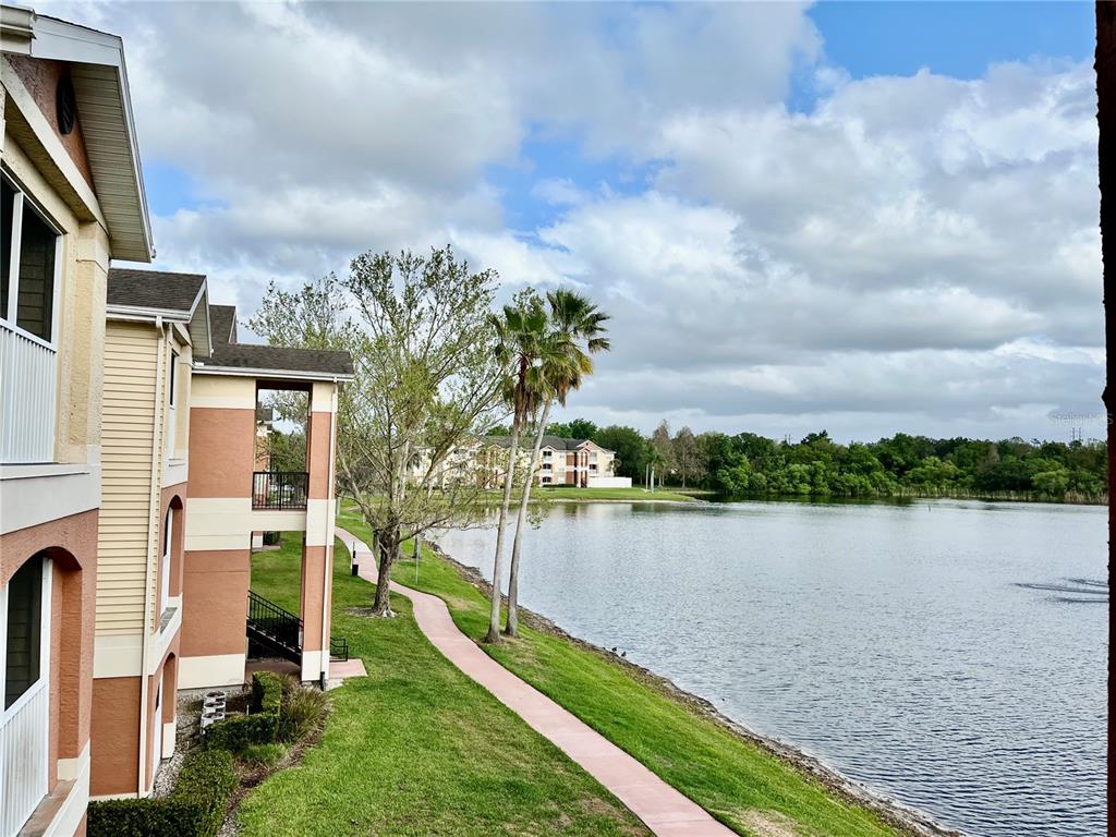 A view from a balcony overlooking a lake, a walking path, and apartment buildings — 1939 SUMMER CLUB APT DRIVE UNIT 315, OVIEDO, FL