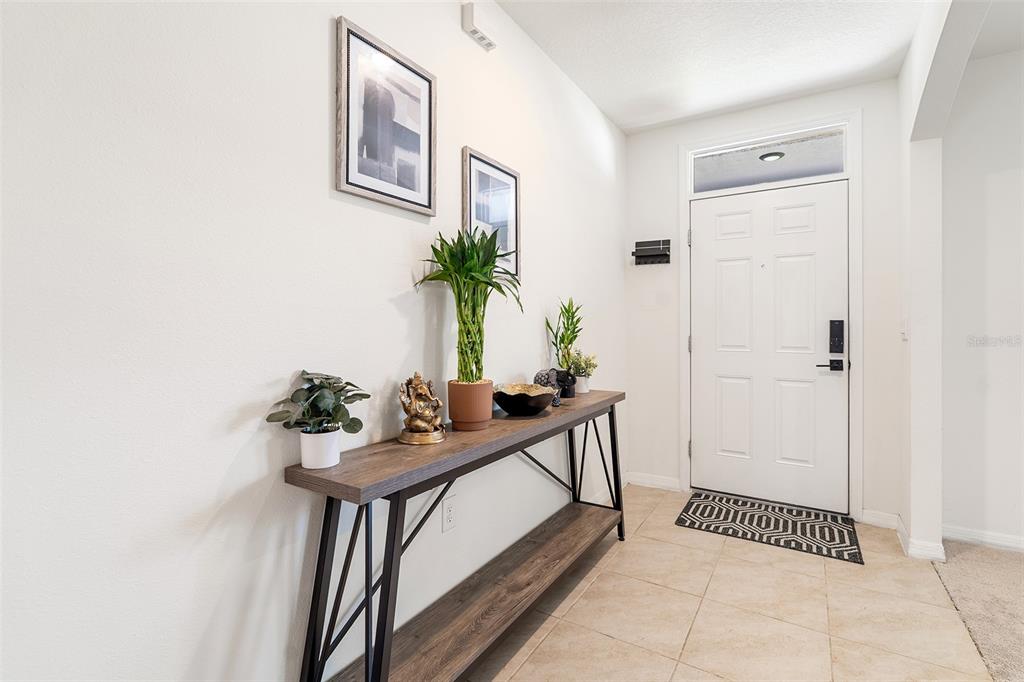 An entryway features a console table with plants and decor against a white wall — 2533 HARMONIA HAMMOCK ROAD, HARMONY, FL