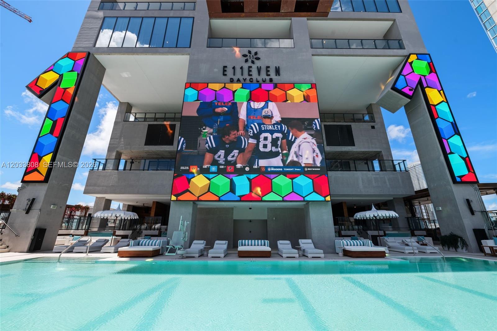 A swimming pool sits in front of a modern building with a large digital screen — 20 NE 11th Street # 4003B, Miami FL 33132, MIAMI, FL