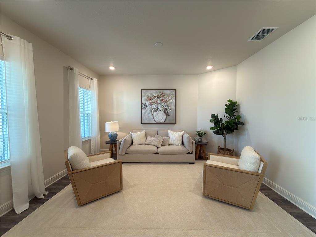 A living room features a beige sofa, two armchairs, a rug, and a potted plant — 10553 SW 98TH PLACE, OCALA, FL
