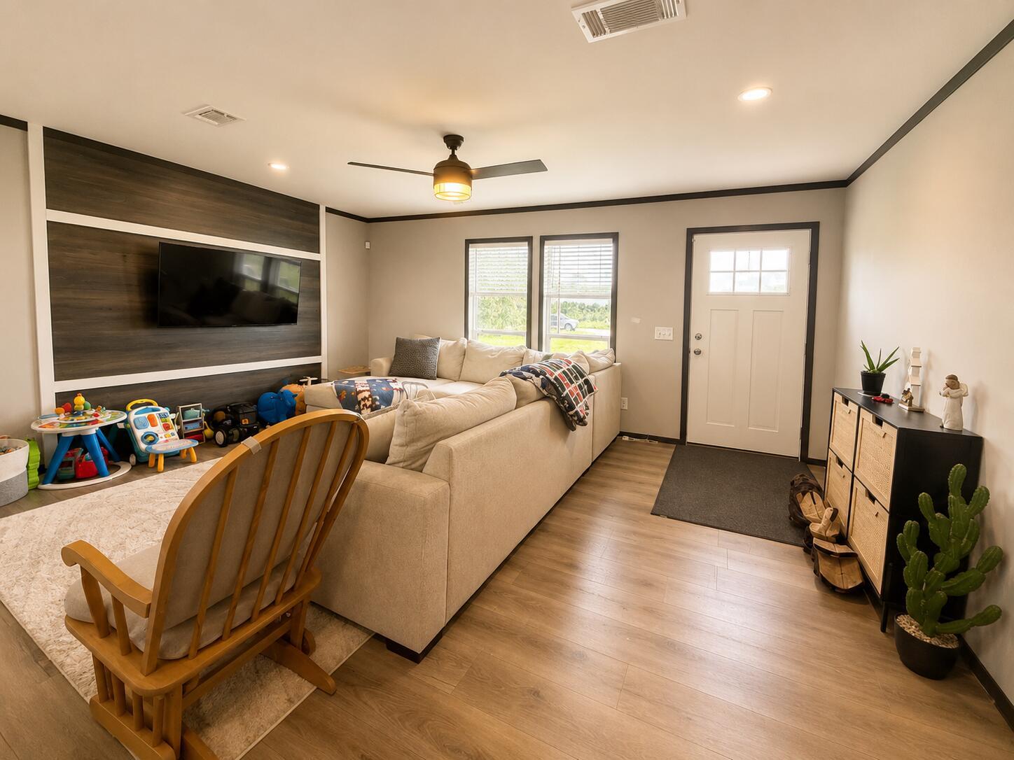 A living room features a wood-paneled accent wall, a sectional sofa, and a rocking chair — 18720 NW 242nd Street, Okeechobee FL 34972, OKEECHOBEE, FL