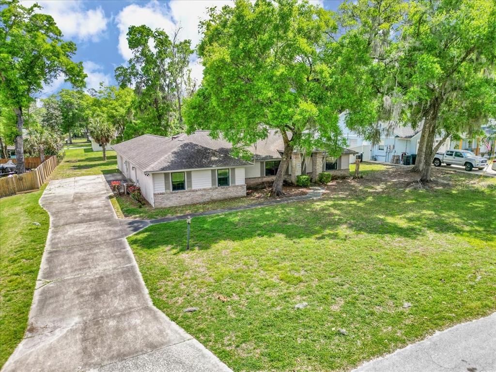 A single-story house with a concrete driveway and large trees in the front yard — 5141 SE 36TH AVENUE, OCALA, FL
