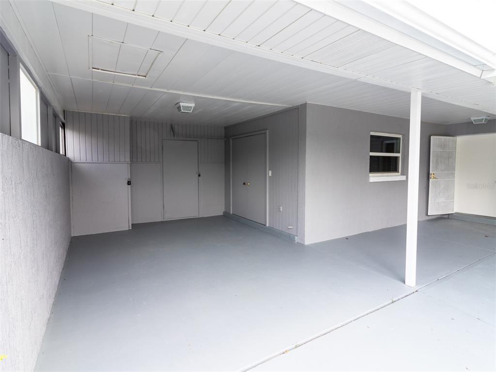 A covered carport with gray painted concrete floors and walls — 474 SPRING LANE, OCALA, FL