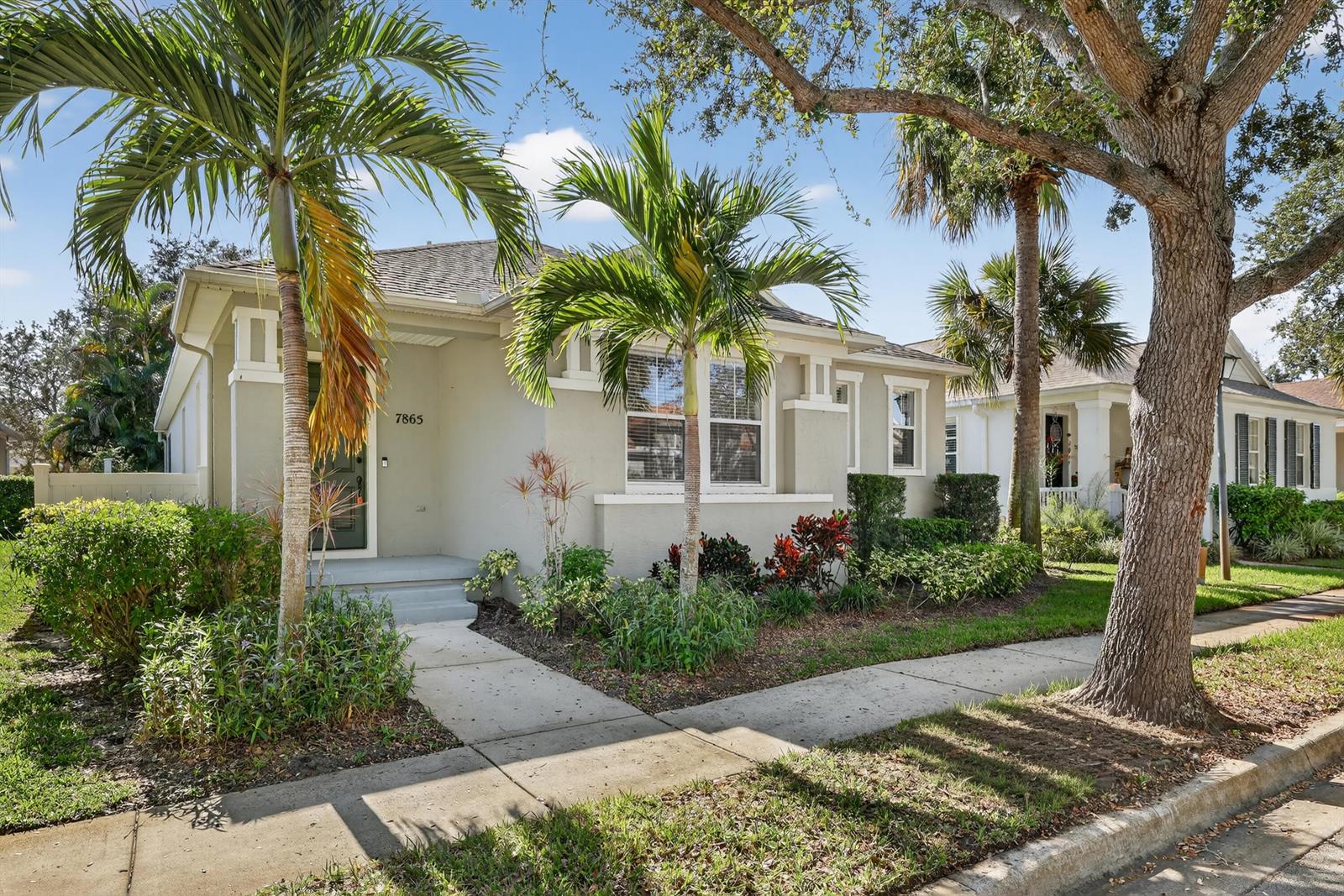 A single-story house with a light-colored exterior, palm trees, and a front walkway — 7865 15th Lane, Vero Beach FL 32966, VERO BEACH, FL