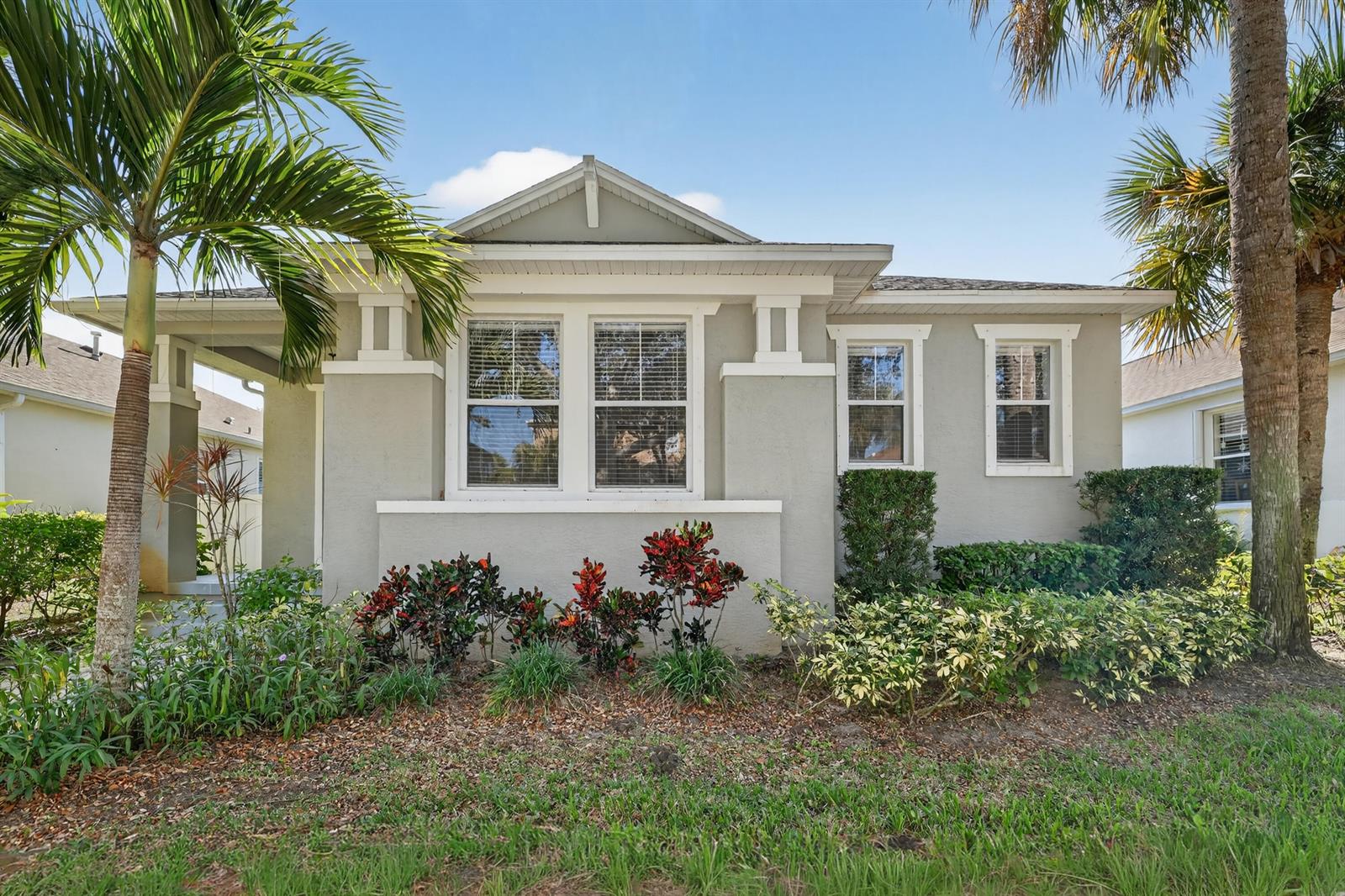 A single-story gray house with a front porch, palm trees, and a landscaped yard — 7865 15th Lane, Vero Beach FL 32966, VERO BEACH, FL