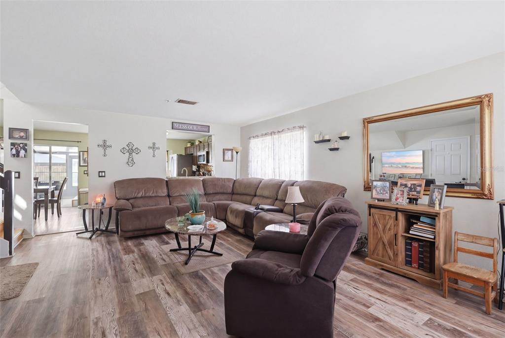 A living room features a large brown sectional sofa, a recliner, and wood-look flooring — 3440 ALLSTON LANE, WINTER PARK, FL