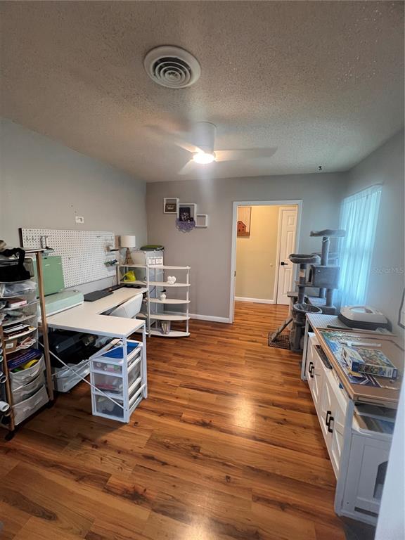 A craft room features wood-look flooring, a white desk, a pegboard, and a cat tree — 10626 BRESSLYN BOULEVARD, ORLANDO, FL