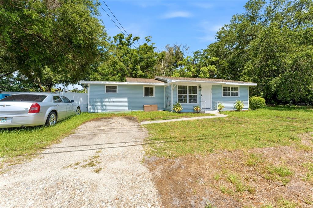 A light blue, single-story house with a gravel driveway and a white front door — 4610 71ST STREET N, ST PETERSBURG, FL