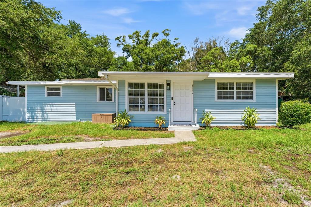 A single-story, light blue house with a white front door and a concrete walkway — 4610 71ST STREET N, ST PETERSBURG, FL