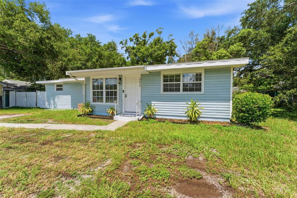 A light blue, single-story house with a white door and a small front yard — 4610 71ST STREET N, ST PETERSBURG, FL