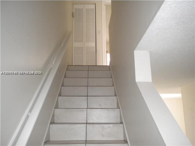 A set of tiled stairs leads upward toward a white louvered closet door — 260 NW 107th Ave # 207, Miami FL 33172, MIAMI, FL