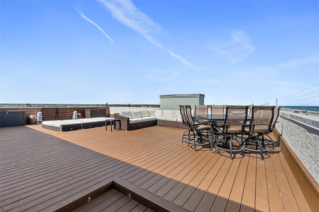 A rooftop deck features a large sectional sofa, a dining set, and ocean views — 3390 OCEAN SHORE BOULEVARD UNIT 402, ORMOND BEACH, FL