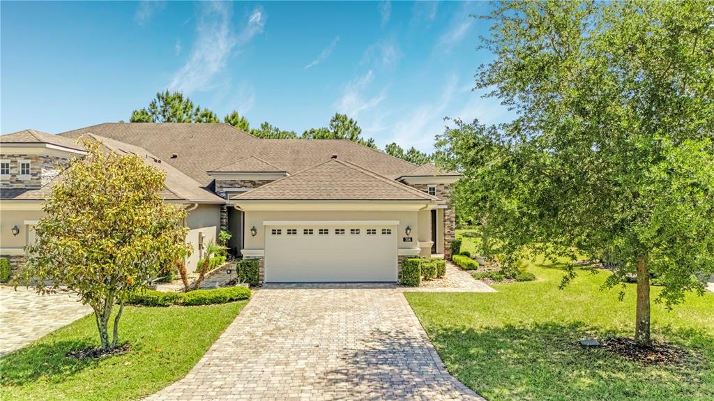 A single-story house with a paved driveway, a two-car garage, and surrounding landscaping — 708 ALDENHAM LANE, ORMOND BEACH, FL