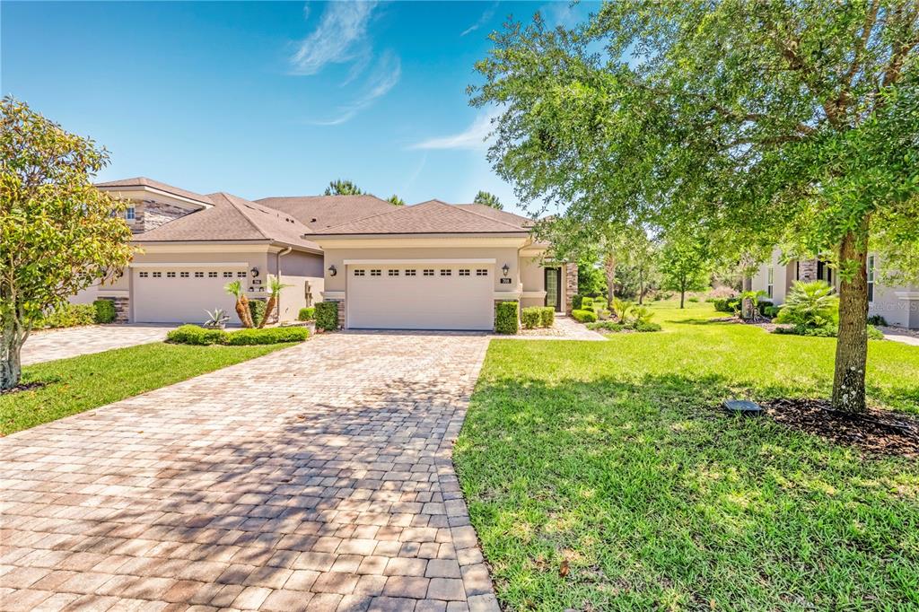 A paved driveway leads to the two-car garage of a single-story suburban house — 708 ALDENHAM LANE, ORMOND BEACH, FL