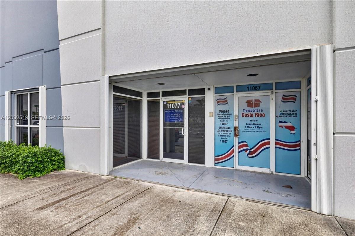 The exterior view shows the glass-fronted entrances of two adjacent commercial units with signage — 11077 NW 122nd St # 11, Medley FL 33178, MEDLEY, FL