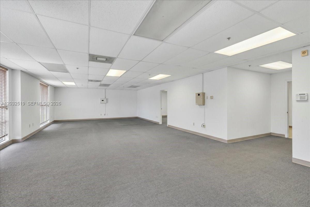 An empty office space features gray carpeting, white walls, and a drop ceiling with recessed lighting — 11077 NW 122nd St # 11, Medley FL 33178, MEDLEY, FL