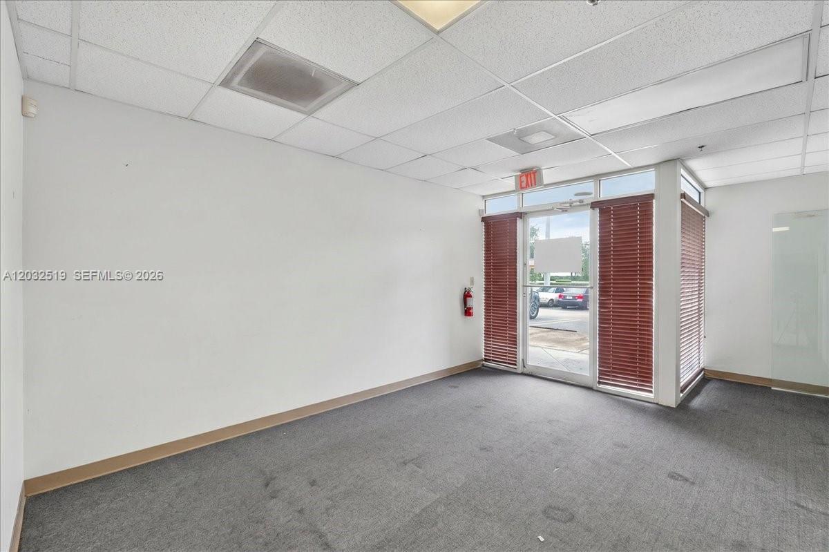 An empty office space features white walls, gray carpeting, a drop ceiling, and glass doors — 11077 NW 122nd St # 11, Medley FL 33178, MEDLEY, FL