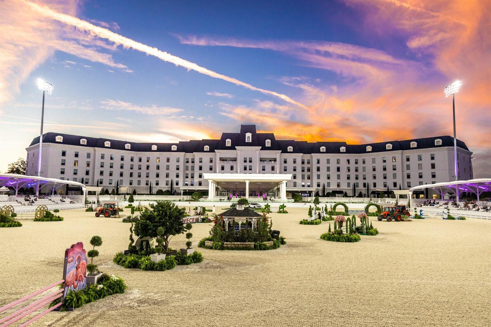 A large white hotel building overlooks a sandy equestrian arena with jumps at sunset — Lot 29 NW 112th Avenue, Ocala FL 34482, OCALA, FL
