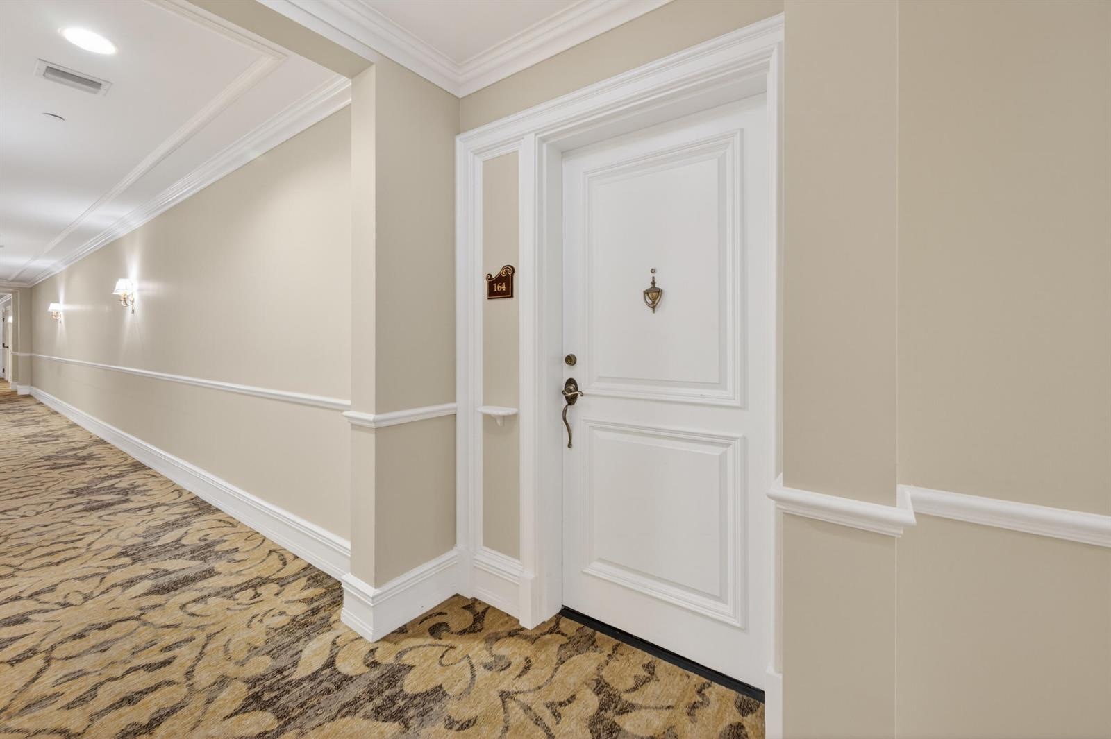 A white door with a brass knocker and number 164 sits in a carpeted hallway — 16135 Emerald Estates Drive # 164, Weston FL 33331, WESTON, FL