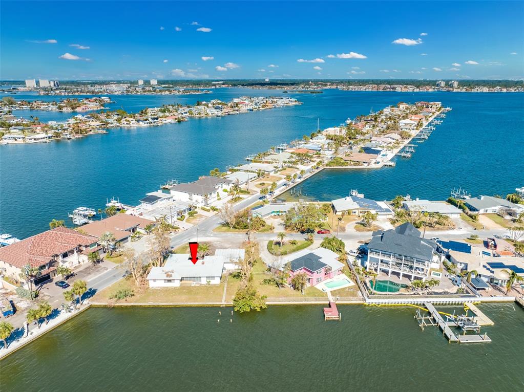 An aerial view shows a waterfront house with a red arrow pointing to its roof — 5412 PALI WAY, ST PETE BEACH, FL