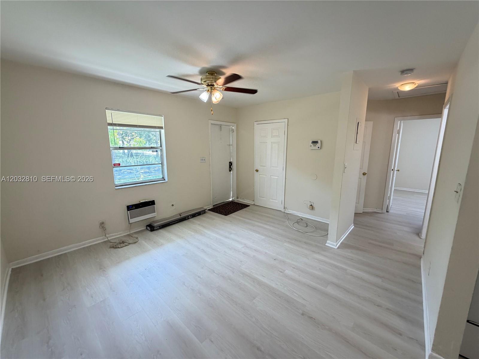 An empty room features light-colored wood-look flooring, a ceiling fan, and a window air conditioner — 4801 SW 18th St # 2, West Park FL 33023, WEST PARK, FL