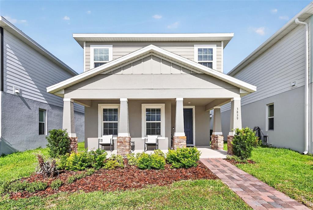 A two-story house with a covered front porch, stone-based columns, and a brick walkway — 3859 DENALI DR, APOPKA, FL