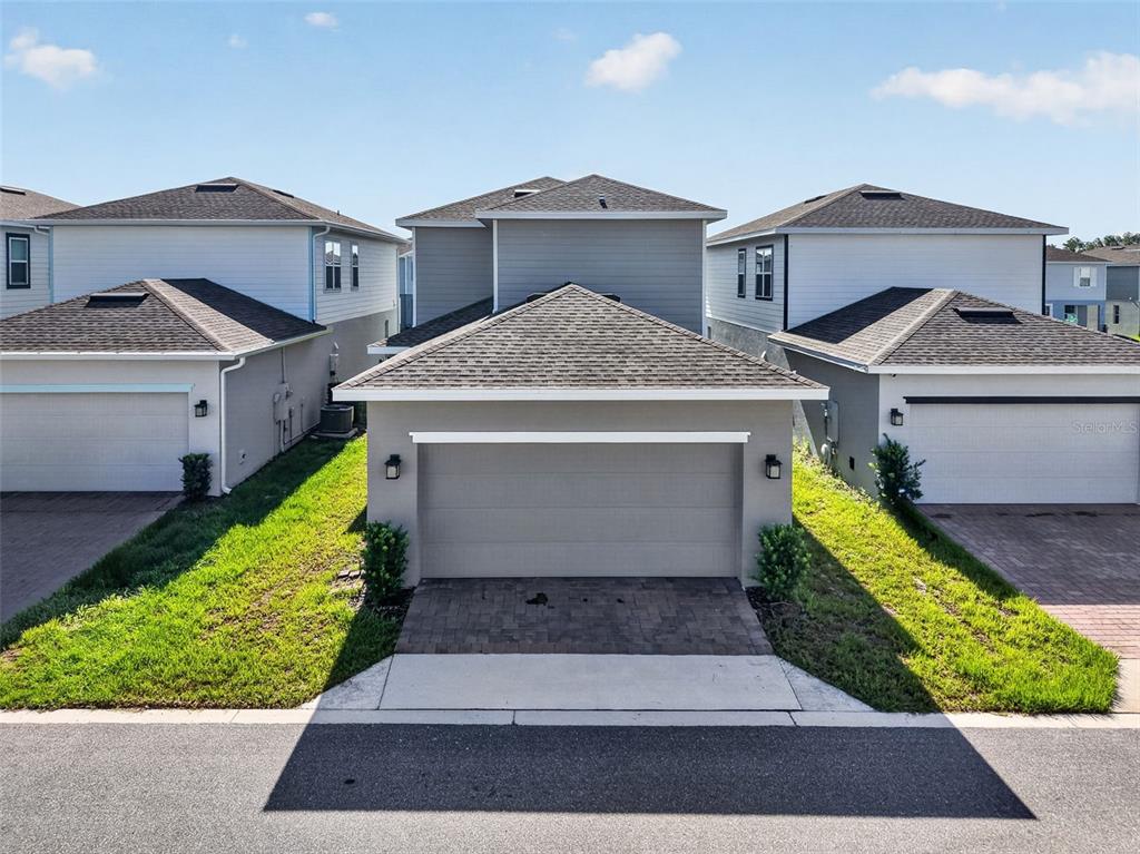 An exterior view of a gray two-story house with a paved driveway and attached garage — 3859 DENALI DR, APOPKA, FL