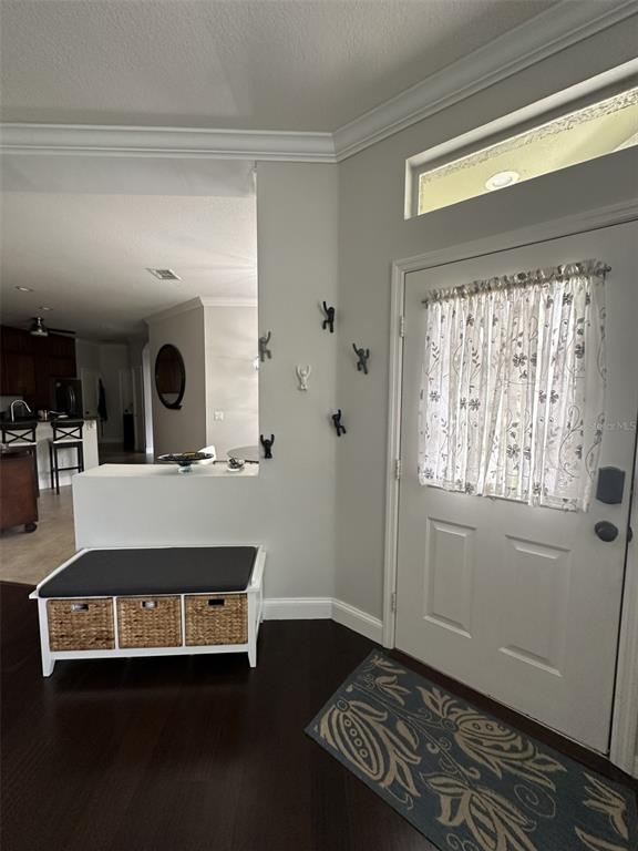 An entryway features a white storage bench, wall-mounted hooks, and a door with a curtain — 19113 DOVES LANDING DRIVE, TAMPA, FL