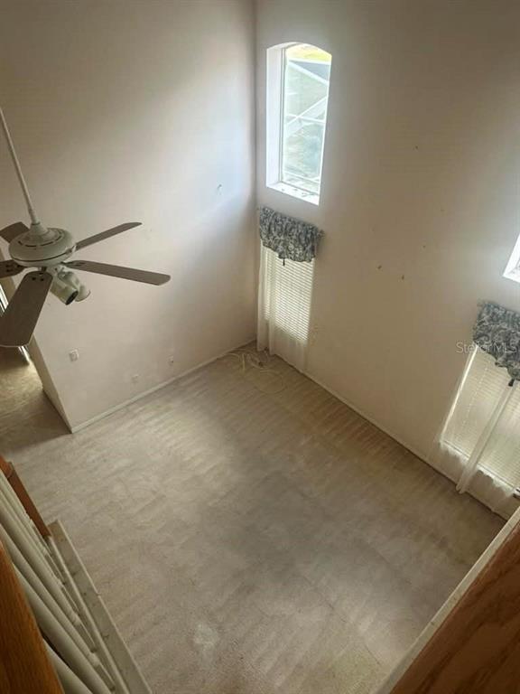 An elevated view of a living room with high ceilings, carpeted floors, and a ceiling fan — 948 TROON CIRCLE, DAVENPORT, FL