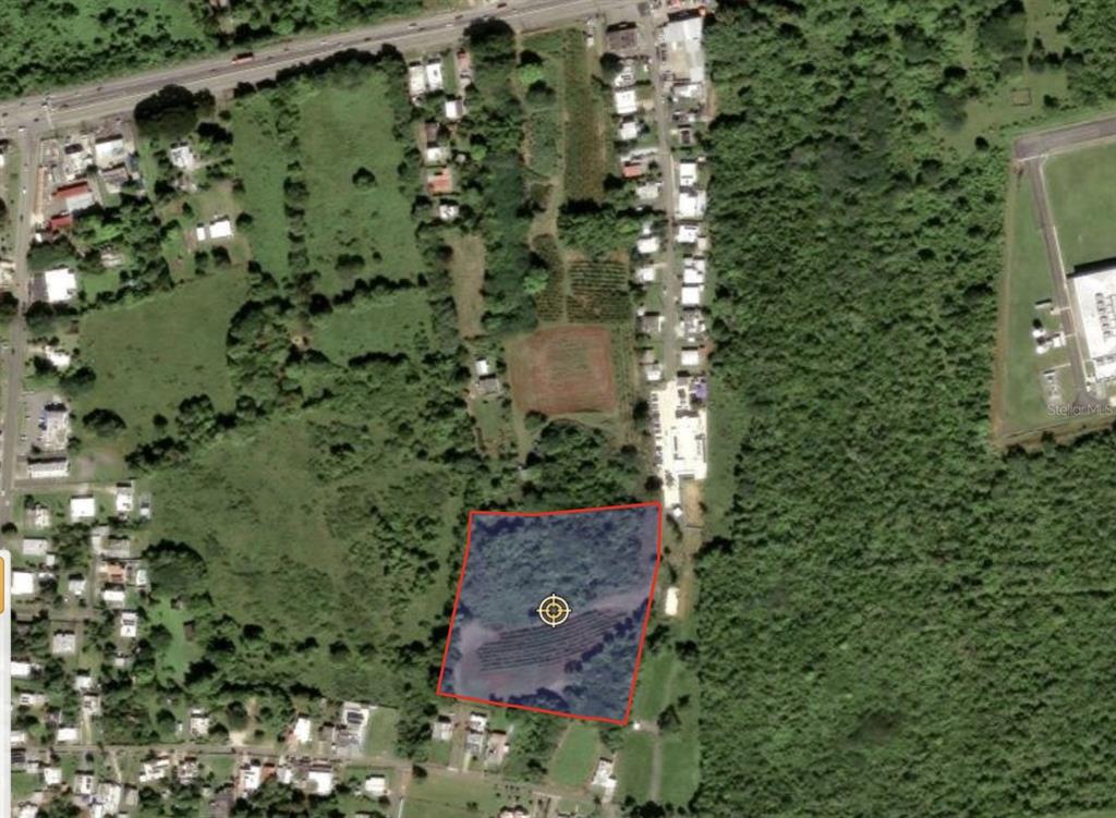 An aerial view shows a rectangular plot of land outlined in red amidst vegetation — BARRIO CEIBA BAJA, AGUADILLA, PR