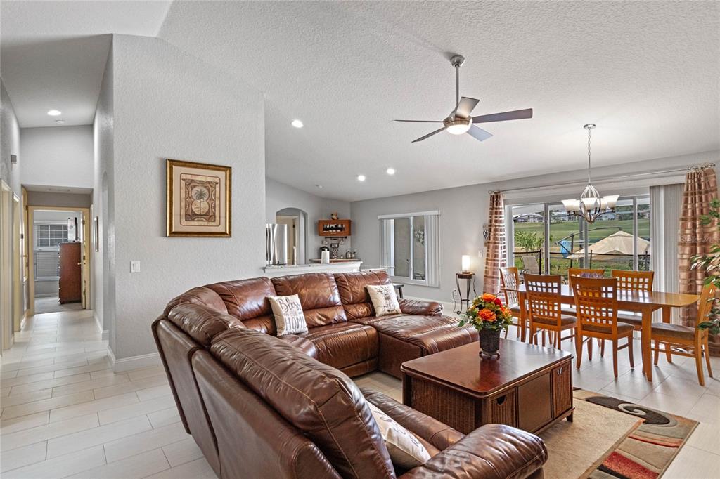 A living room features a brown leather sectional, a coffee table, and an adjacent dining area — 300 KINGS WAY, DAVENPORT, FL
