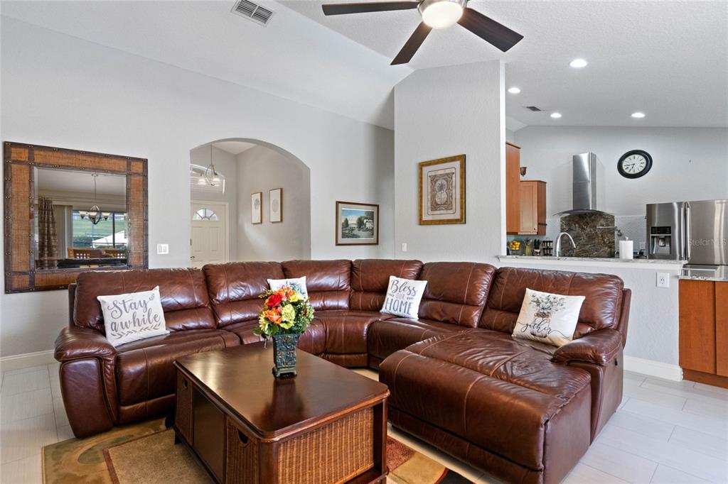A living room features a large brown leather sectional sofa, a coffee table, and tile flooring — 300 KINGS WAY, DAVENPORT, FL