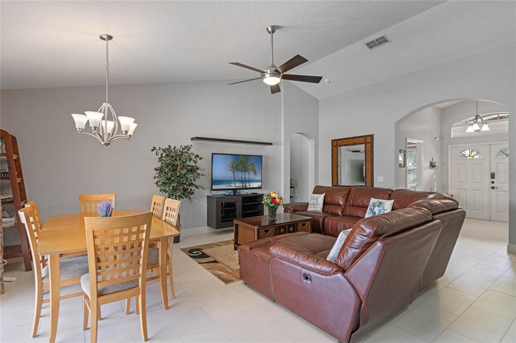 A living and dining area features tile floors, a leather sectional, and a wooden table — 300 KINGS WAY, DAVENPORT, FL