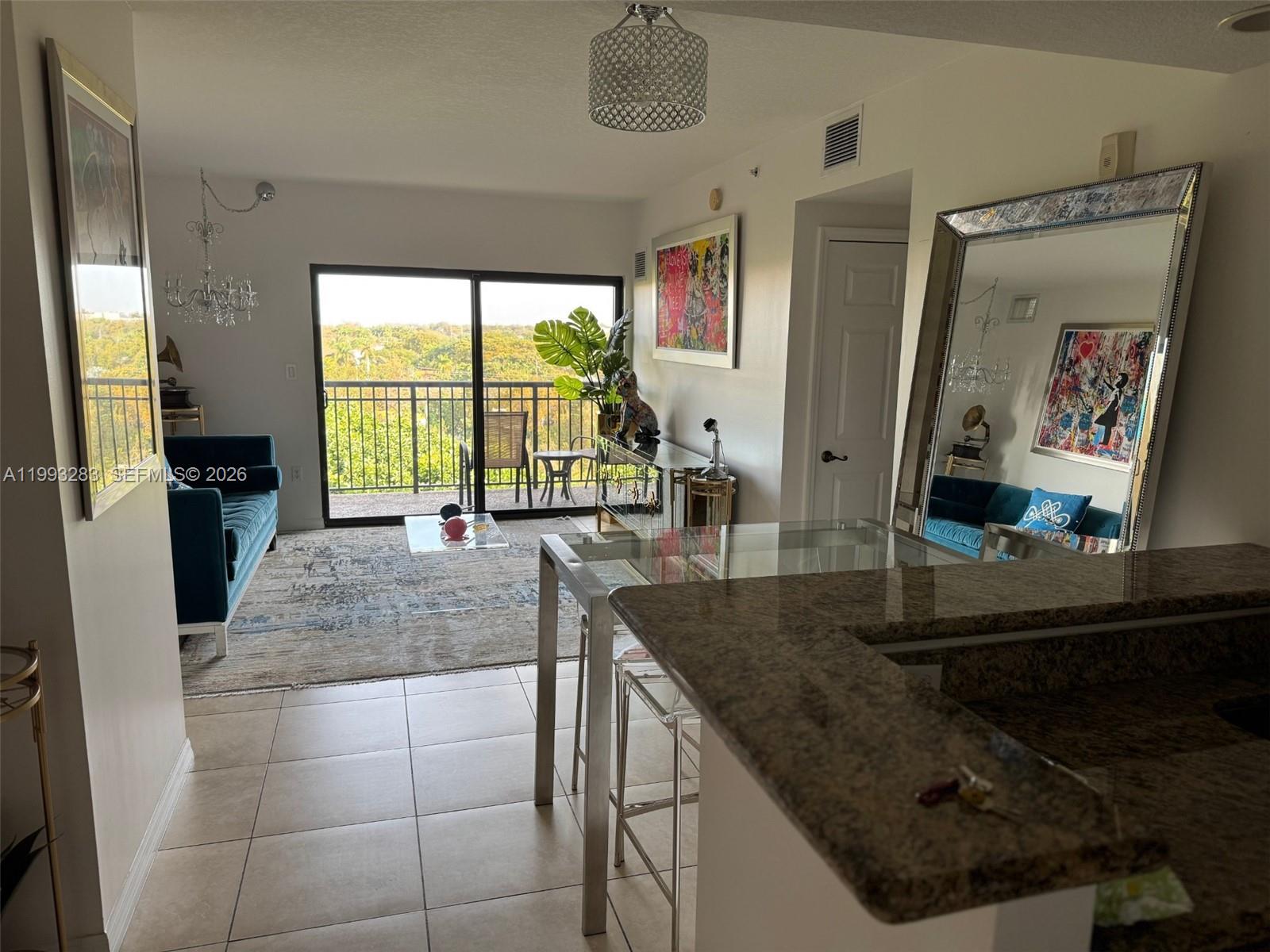A kitchen features wood cabinets, granite countertops, stainless steel appliances, and tile flooring — 3530 SW 22nd St # 706, Miami FL 33145, MIAMI, FL