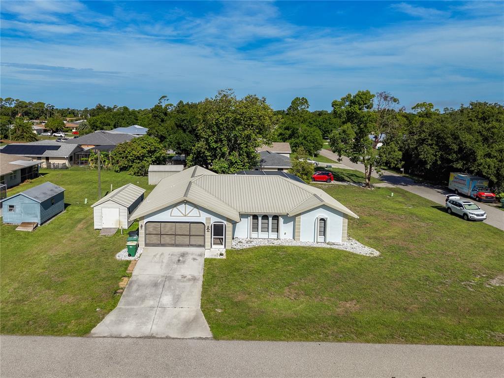 An aerial view of a single-story house with a metal roof and a concrete driveway — 3637 IDLEWILD STREET, PUNTA GORDA, FL