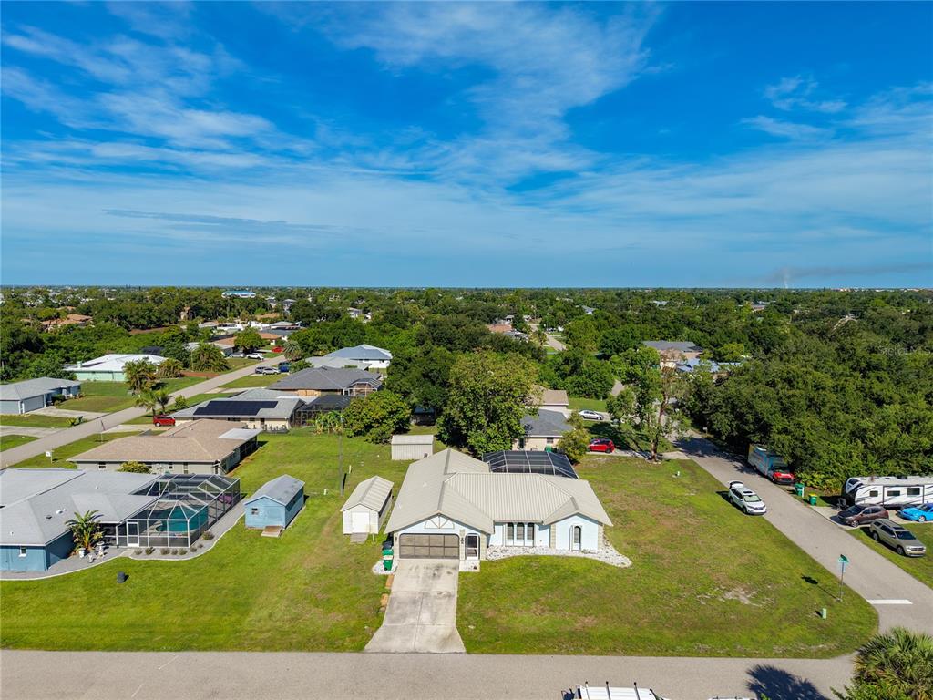 An aerial view shows a single-story house with a metal roof and a large yard — 3637 IDLEWILD STREET, PUNTA GORDA, FL