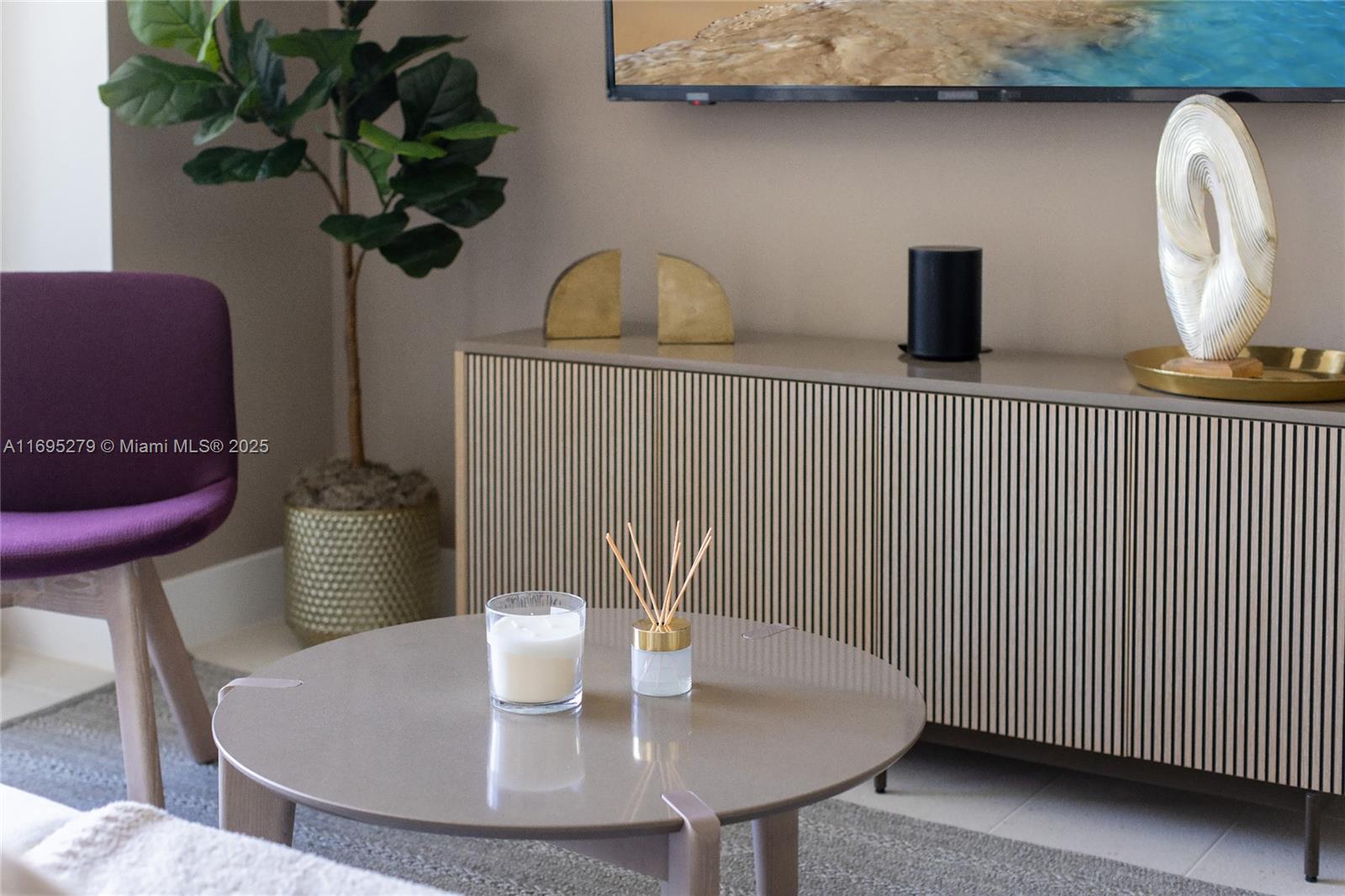 A modern living room features a round coffee table, a slatted sideboard, and a purple chair — 159 NE 6TH ST # 3209, Miami FL 33132, MIAMI, FL