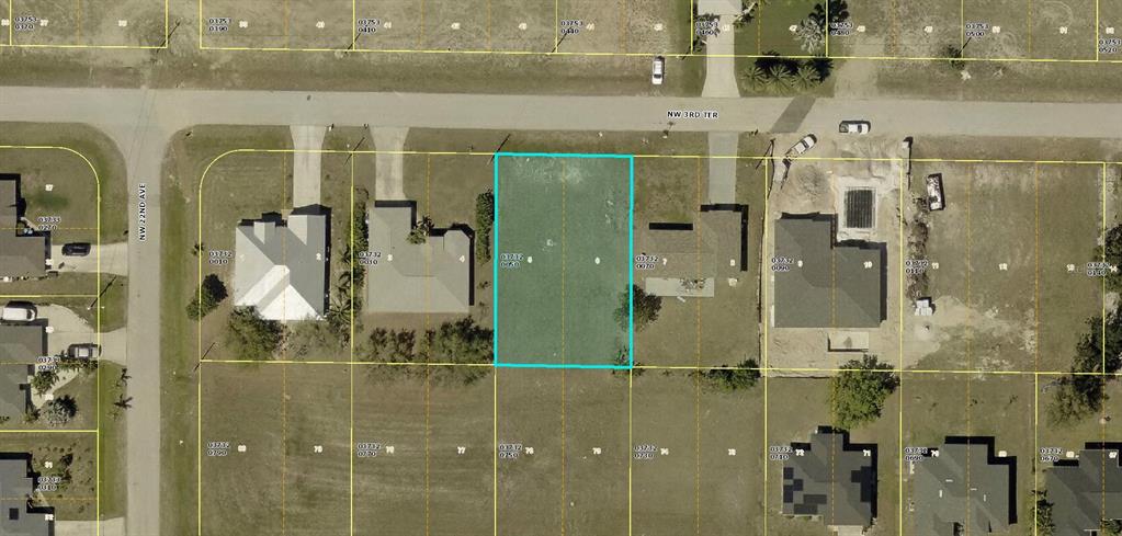 An aerial view shows a vacant residential lot highlighted in blue along a paved road — 2056 NW 3RD TERRACE, CAPE CORAL, FL