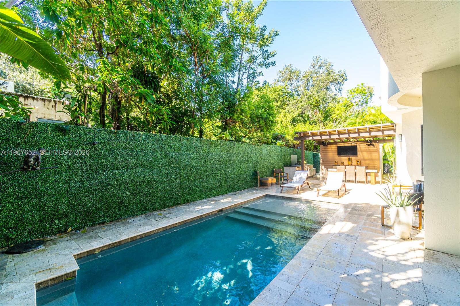 A backyard features a rectangular swimming pool, a patio, and a covered outdoor dining area — 2752 Brickell Ct, Miami FL 33129, MIAMI, FL