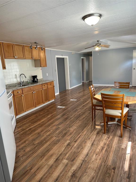 A kitchen and dining area with wood-look flooring, wooden cabinets, and light blue walls — 17110 LIVE OAK LANE, MONTVERDE, FL