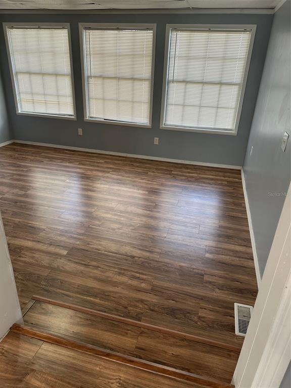 A room with wood-look flooring, three windows with blinds, and a step-down transition — 17110 LIVE OAK LANE, MONTVERDE, FL
